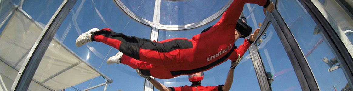 Photo de deux personnes dans un simulateur de chute libre de la société air vertical.