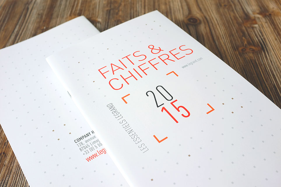 Photographie de la couverture du document corporate Faits & Chiffres 2015 du Groupe Legrand. Il s'agit d'un fond blanc avec du texte orangé.