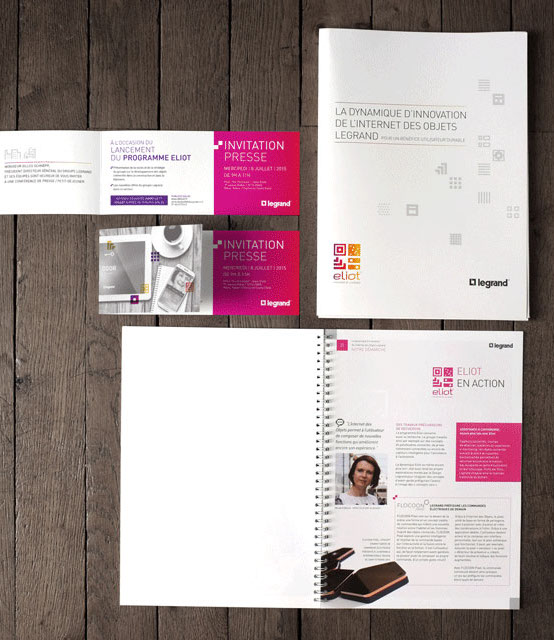 Photo d'un document ouvert, d'une invitation et d'une chemise pour un dossier de presse. Les documents sont photographiés de dessus.
