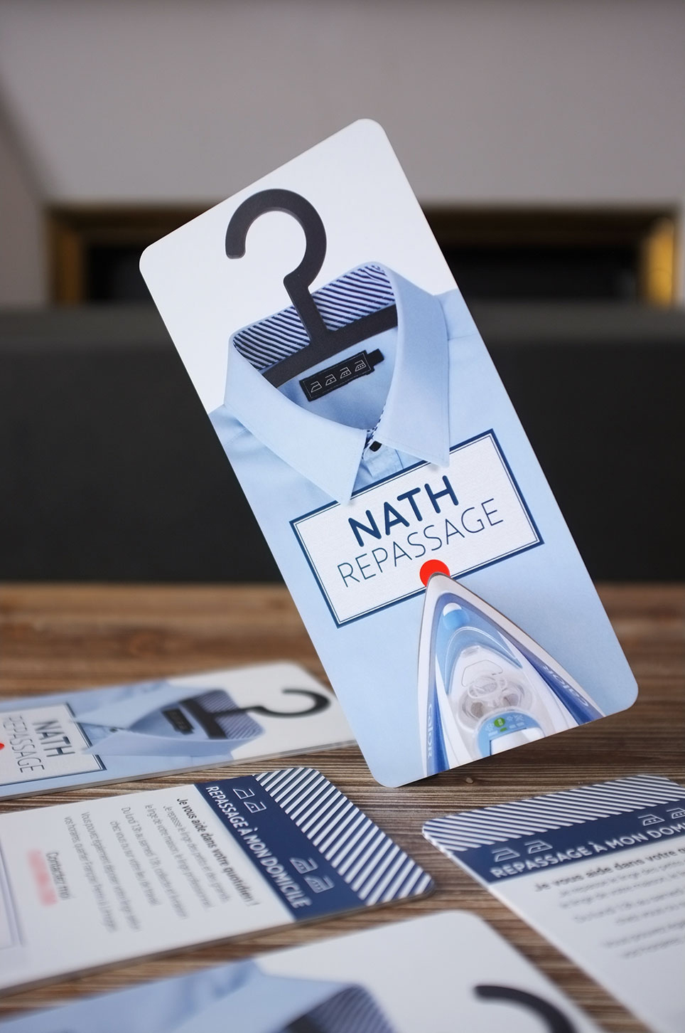 Photographie des flyers Nath repassage. Un flyer est en équilibre sur le coin inférieur gauche.